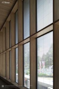 Innenansicht von großen Fenstern mit windstabilen Raffstores. Der Wind kann sie nicht treffen, weil sie im Scheibenzwischenraum angebracht sind.