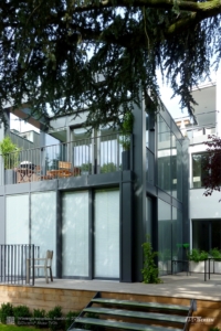 Modernes Wohnhaus: Fenster und Terrassentür haben sturmfeste Raffstores im Scheibenzwischenraum als Jalousie.