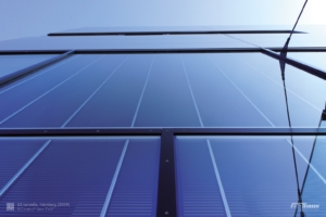 Blick auf eine Glasfassade. Den Raffstores kann Wind nichts anhaben, da sie im Glas sitzen. Ein Windsensor ist selbst bei hoher Windstärke unnötig.